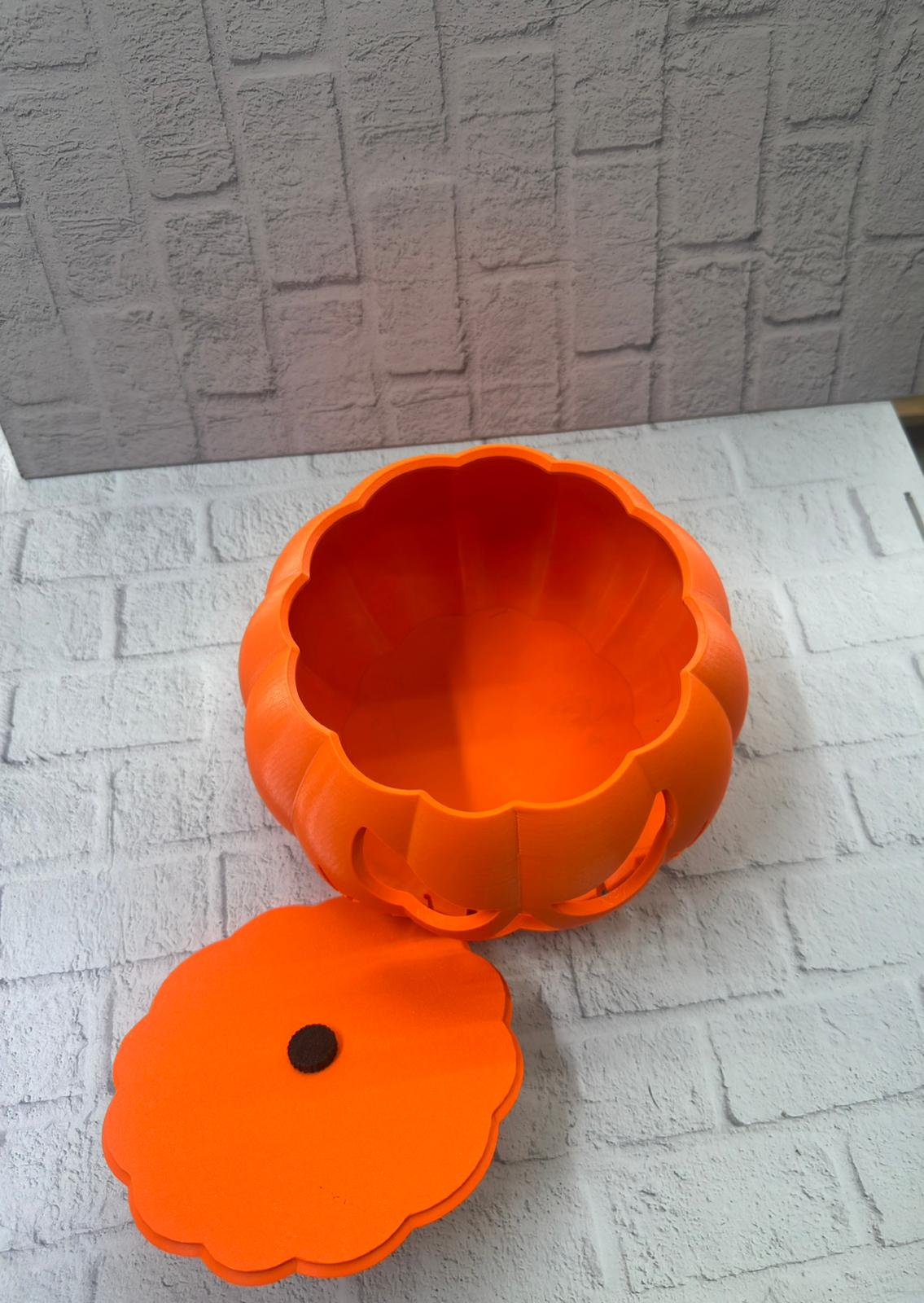 hem dekoratif görünümü hem de işlevsel kullanımıyla dikkat çeken özel bir tasarımdır. Canlı turuncu rengi ve kabartma yüz detayları sayesinde Halloween konseptinin eğlenceli atmosferini evinize taşır. Ürünün kapağı kolayca açılıp kapanabilir yapıda olduğu için iç kısmı pratik bir şekilde kullanılabilir.Bu kutu; şekerlik