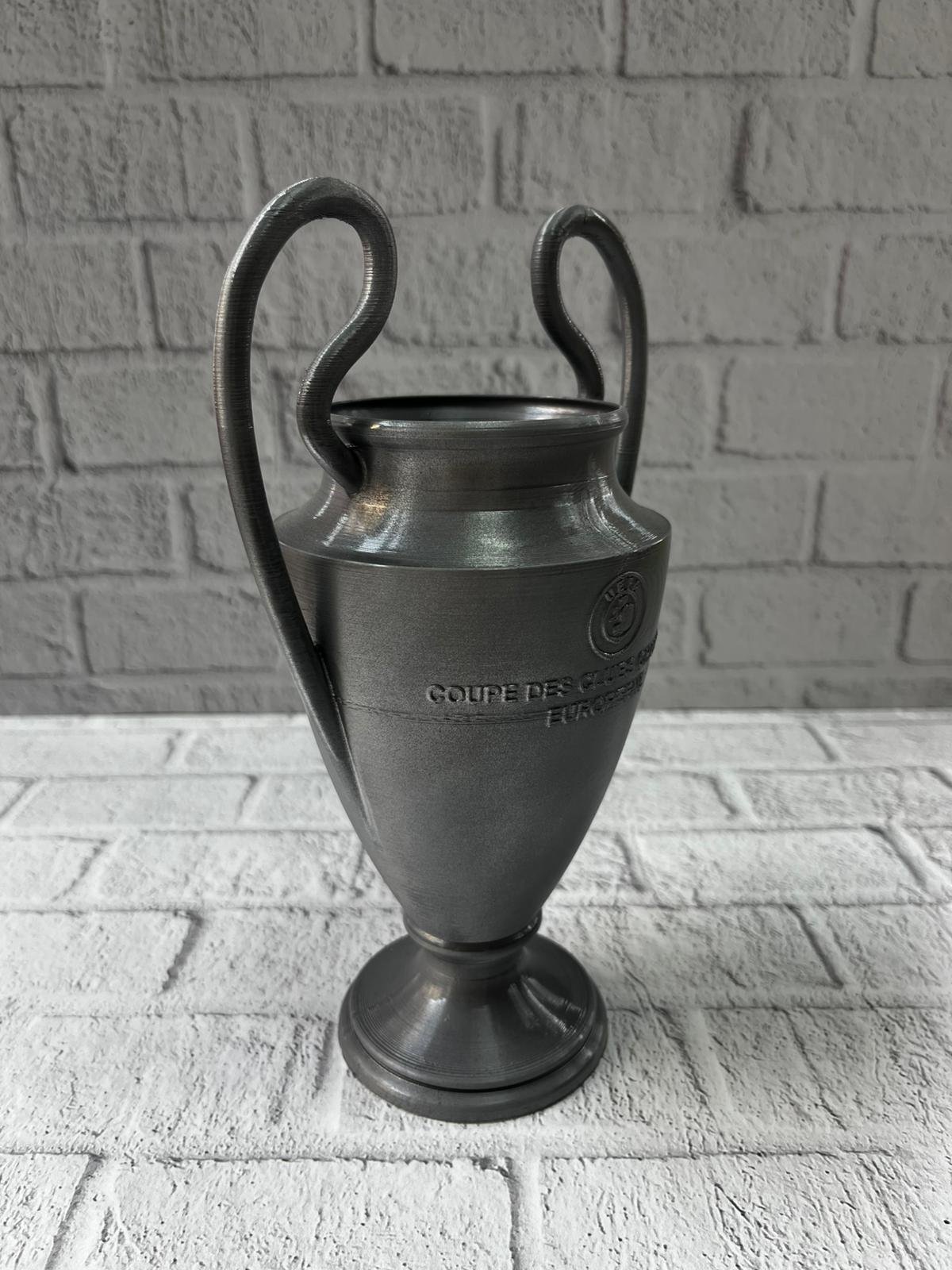 WhatsApp Image 2025 12 11 At 12.17.06 2 700x933 Füme Şampiyonlar Kupası 25cm Modern Dekor Ödül Biblo najmaddin.com koleksiyonerler ve futbol tutkunları için anlamlı bir dekor parçası olmasının yanı sıra ofislerde motivasyon objesi olarak da etkileyici bir görünüm sunar. Ev dekorunda modern ve güçlü bir atmosfer yaratmak isteyenler için ideal bir seçimdir. Doğum günü